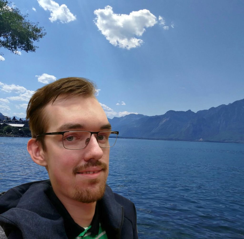 WordPress Engineer Aleksas Pantechovskis mit See und Bergen im Hintergrund