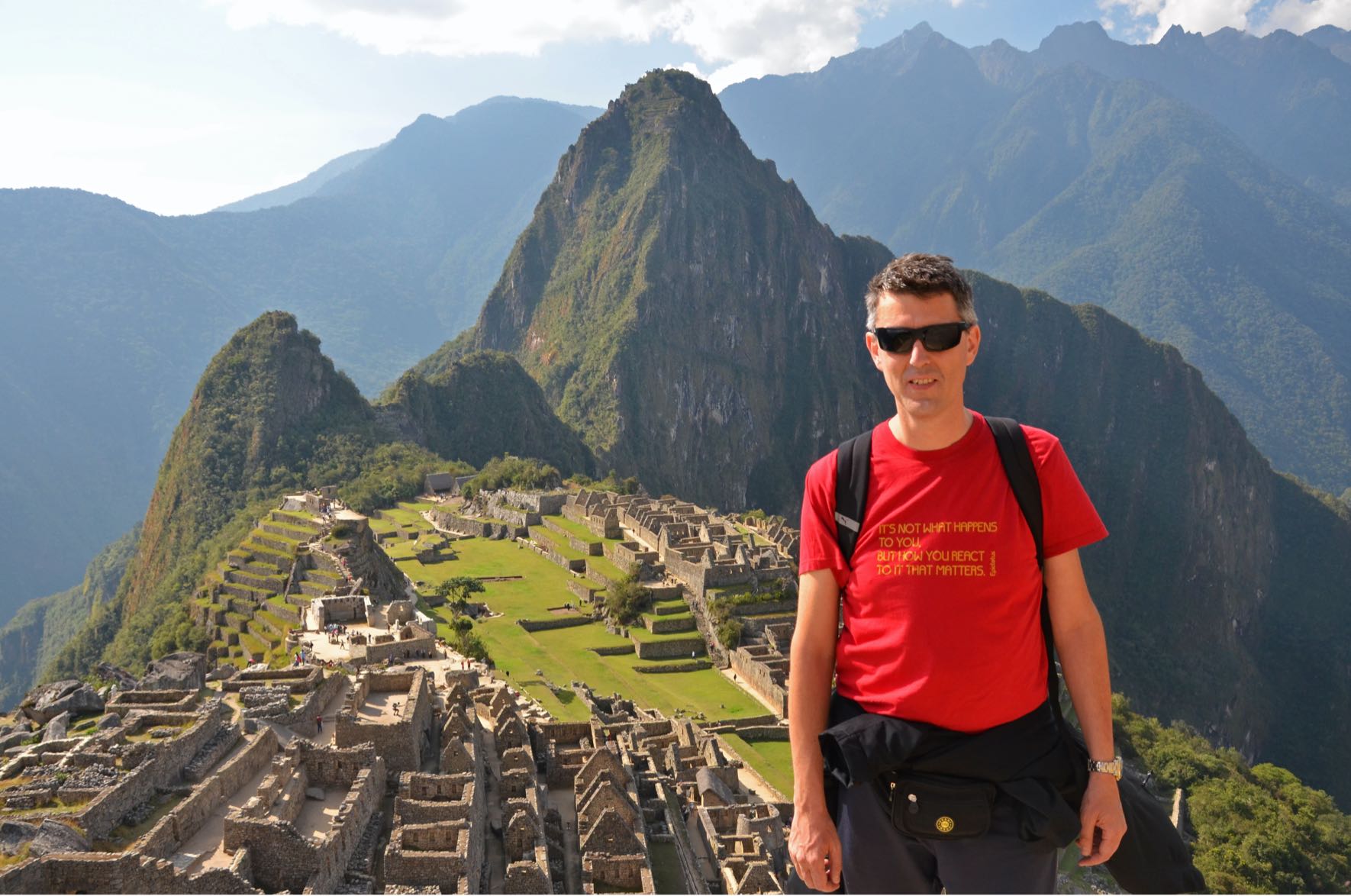 Auf diesem Bild steht Giancarlo mit Sonnebrille vor der Inka-Zitadelle von Machu Picchu, Peru.