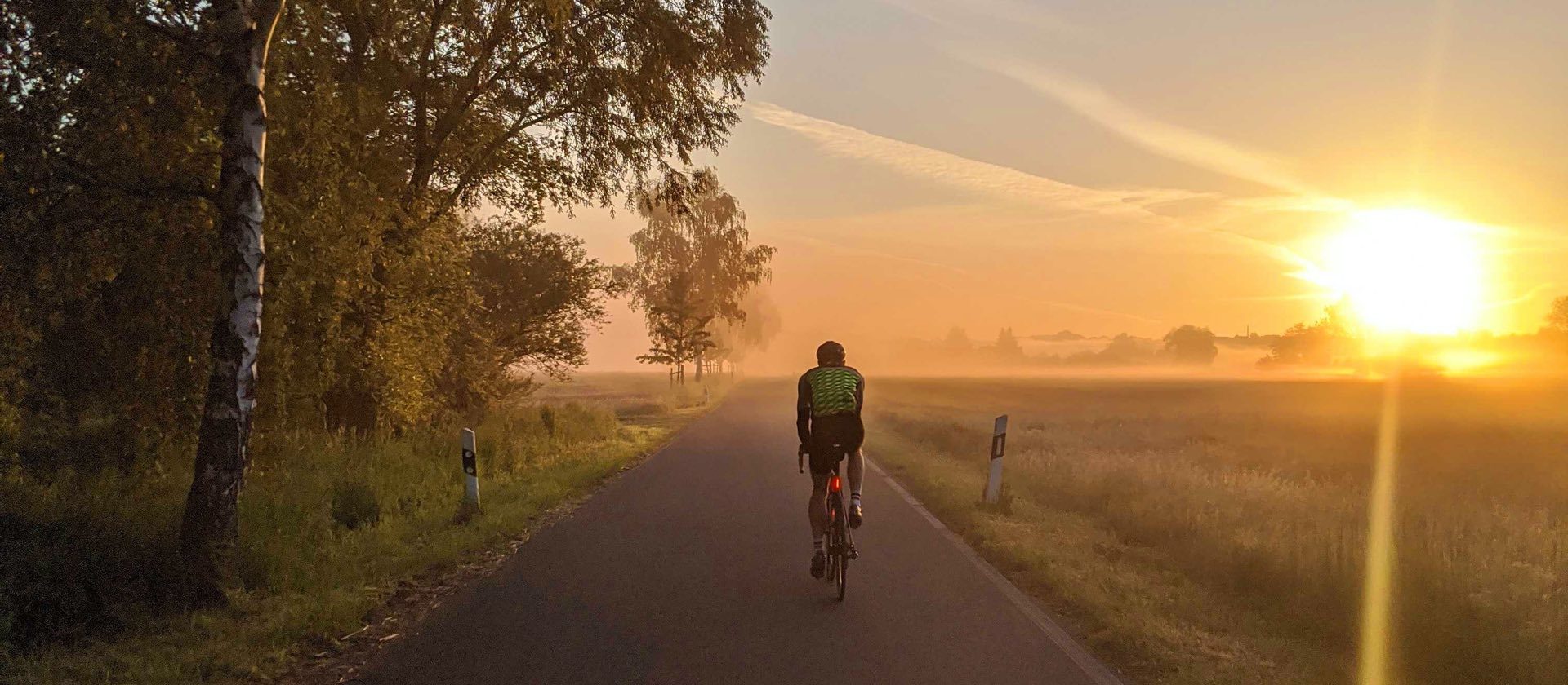 Frank Bültge rides on his bike into the sunset