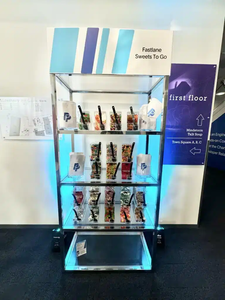 Large PayPal-branded display case with various sweets with a sign saying "Fastlane Sweets To Go"